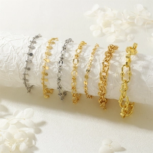 Bracciali a catena minimalisti in oro e argento su espositore bianco elegante