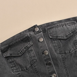 Détail de la robe en jean noir avec boutons en métal argenté et doubles poches
