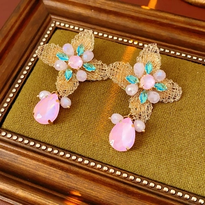 Detailed shot of vintage mesh butterfly earrings with pink and blue crystal pendants