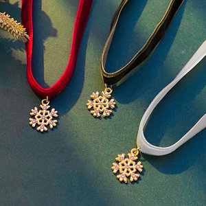 Three velvet Christmas chokers in red black and white with gold snowflake pendants