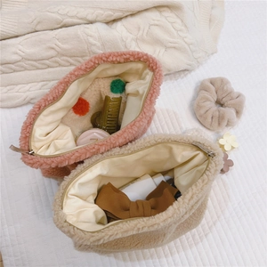 Interior view of soft faux fur cosmetic bags in pink and beige showing inner lining