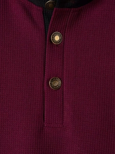 Dettaglio della trama a nido d'ape bordeaux e del colletto henley a tre bottoni