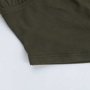 Gros plan détaillé montrant la couture précise à double aiguille sur tissu en maille olive
