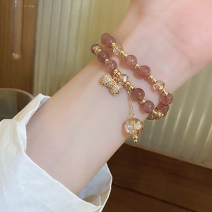 Close-up of multi-layer beaded bracelet with bow pendant and translucent pearls