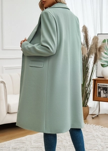 Back view of a long mint green wool coat with a relaxed fit and stylish back slit detail