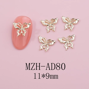 Detail view of golden hollow butterfly nail art charms measuring 11x9mm on pink nail