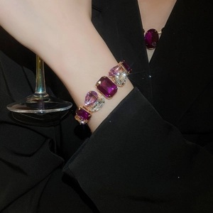 Close-up of vintage gold necklace set with purple and clear faceted gemstones