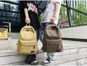 Minimalist canvas backpacks in beige and army green shown on models in an urban setting