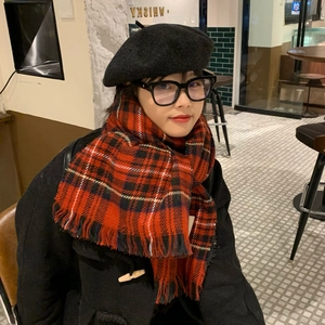 Close-up of a model wearing a red plaid vintage scarf with a black beret and glasses