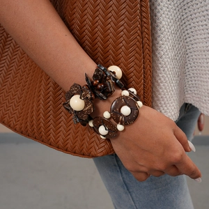 Bohemian wood and coconut shell beaded bracelet set with floral charms worn by model