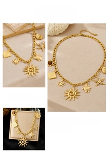 Detailed macro view of golden nautical charms with tiger eye stone on a steel chain