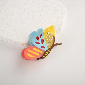 Close-up of butterfly hair claw with colorful acetate wings and sparkling rhinestones