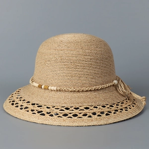 Nahaufnahme eines Raffia-Sonnenhuts mit Lochmuster und exotischem Perlenband Dekor