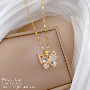 Macro shot of gold butterfly necklace with zircon stones and dimensions 2x1.9cm