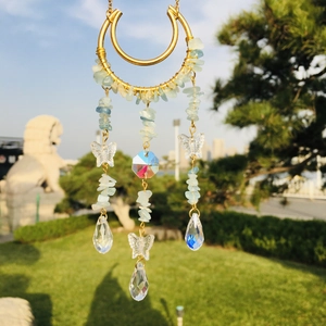 Detail of crystal suncatcher with golden moon frame and blue crushed stones
