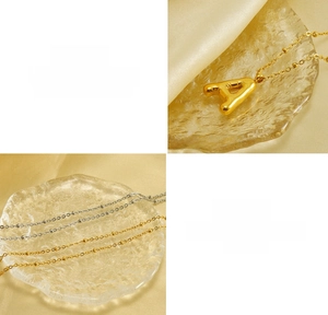 Detailed macro view of 3D bubble letter A pendant in polished gold and silver finishes