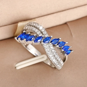 Macro shot of silver ring with marquise blue gemstones and micro-paved zircons