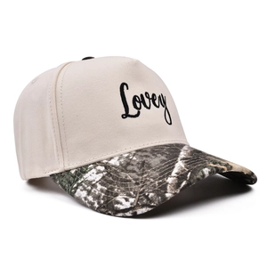 Close-up of the Lovey letter embroidery on a beige cotton hat with a camo visor