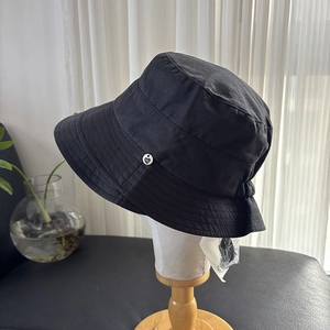 Detail of black summer sun hat fabric with small heart logo on side for women