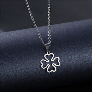 Minimalist stainless steel hollow clover necklace with silver finish on stone pedestal