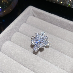 Macro shot of silver flower ear cuff with sparkling zircon crystals on grey velvet