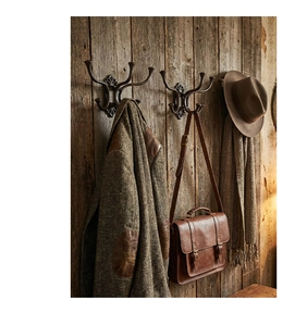 Macro detail of vintage bronze cast iron wall hooks mounted on rustic wooden panels