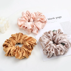 Three-piece set of large satin scrunchies in champagne pink gold and silver colors