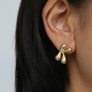 Puffy 18k gold plated letter K balloon stud earring shown on a model ear
