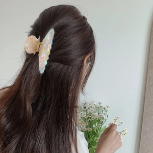 Close-up of iridescent butterfly hair claw clip with colorful acetate finish for women