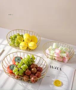 Close-up of golden iron fruit basket with lemons and grapes on marble table