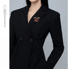 Detail of Christmas candy cane brooch pins with enamel bow on a black blazer lapel
