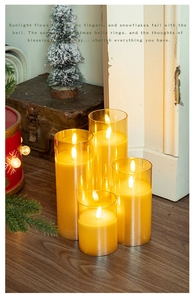 Detail of amber glass LED candles in various heights with warm festive indoor lighting
