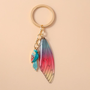 Detail of luxury bird and gradient glitter insect wing keychain with gold metal hardware