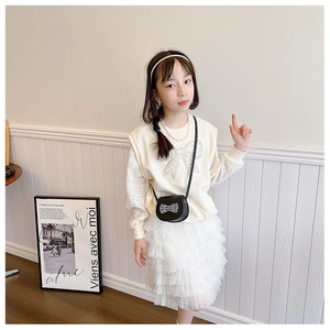 Detail of girls knit vest with pearl bow and layered white tulle tutu skirt set