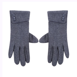 Detailed close-up of dark grey knitted gloves featuring three decorative buttons on the cuffs