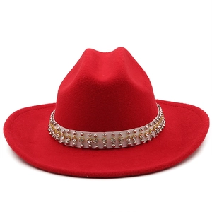 Detail of red wool cowboy hat with silver rivets and yellow rhinestones on white band