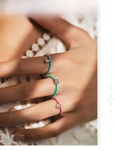 Close-up of three stacked S925 silver rings with colorful enamel and inset zircons