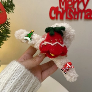 Close-up of plush Christmas hair claw clip with red festive charms and bells