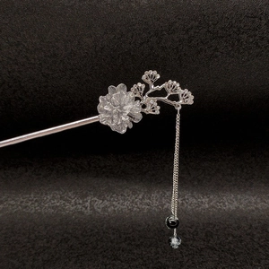 Detail of silver floral hair stick with ink-wash style flower and black bead tassel
