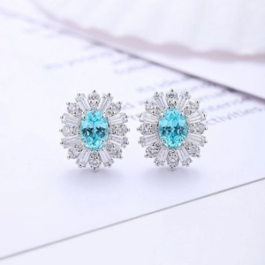 Macro shot of silver stud earrings with oval blue stone and white halo gems