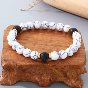 8mm natural lava stone and white marble beaded bracelet with golden spacers on wood