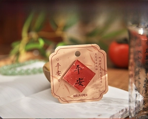 Close-up of a red acrylic Chinese lucky charm magnet with calligraphy on bamboo card