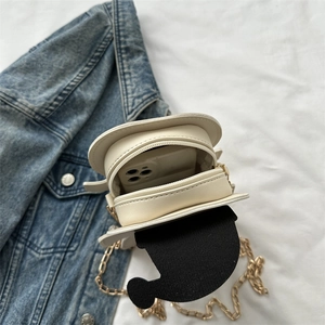 Cream-colored pancake shaped handbag with gold chain strap shown with a smartphone inside