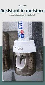 Close-up of wall-mounted automatic toothpaste dispenser with waterproof water droplets