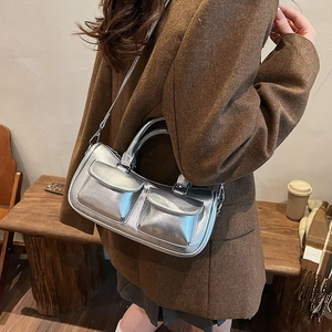 Silver metallic saddle bag with double front pockets shown on model in cafe setting