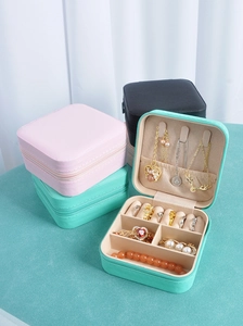 Close-up of portable jewelry organizers in pink, mint, and black with zipper closure