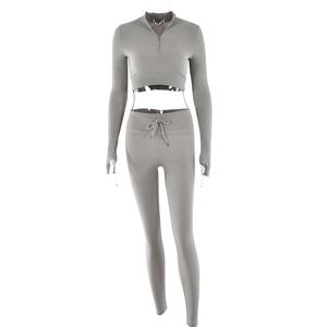 Detail of grey ribbed workout set showing thumb holes and half-zip high collar top