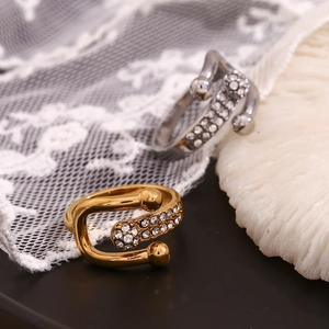 Dettaglio di anelli a fibbia a U in oro 18K e argento con micro-pavé di cristalli