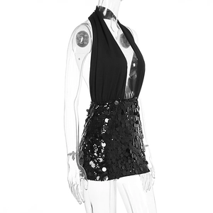 Close-up of black halter dress featuring a sequined mini skirt and matte V-neck bodice
