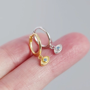 Detailed view of S925 silver evil eye hoop earrings with blue stones in gold and silver